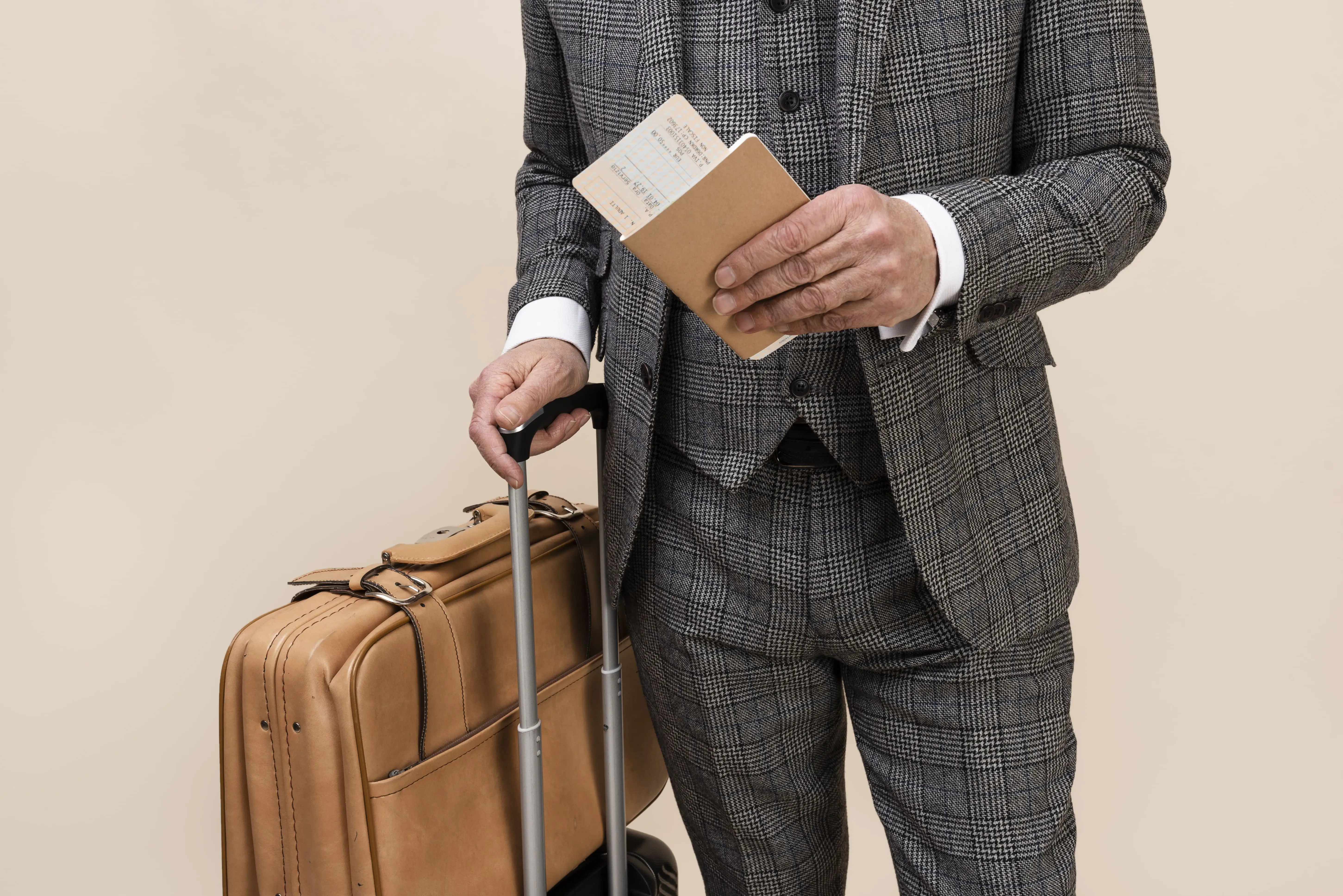 Empresario esperando con su maleta y pasaporte en mano